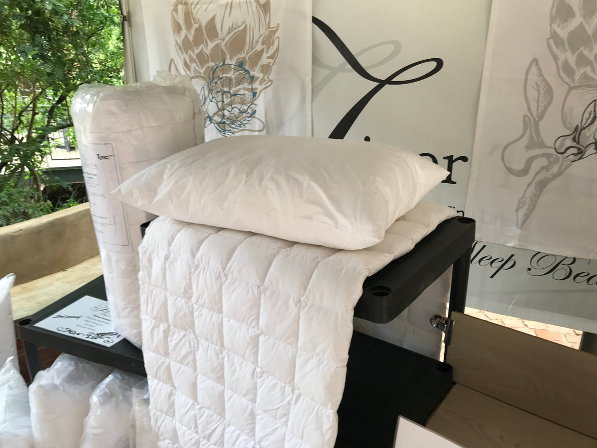 White pillow and quilted duvet inner displayed beside packaged bedding
